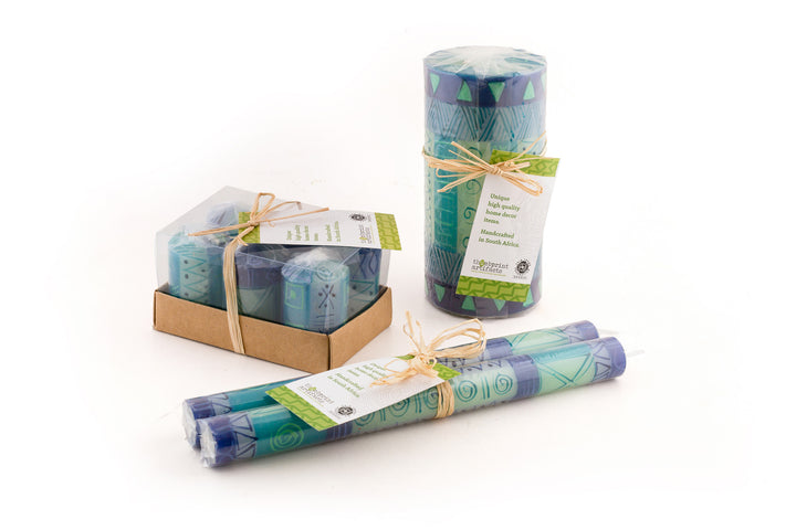 Photo of the candle packaging.  Votives come in a 6-pack tied with a story.  Other shapes come wrapped in cello with a story card.  Tapers are in a pair, wrapped with a story card. 