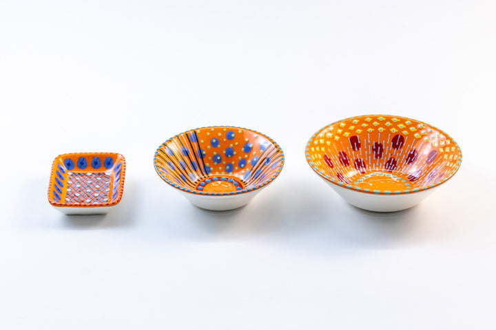 3 ceramic bowls with orange base color to compare the size of the (from left) Tiny rectangle bowl, Mini-Nut Bowl, and Nut Bowl. Collect all three!