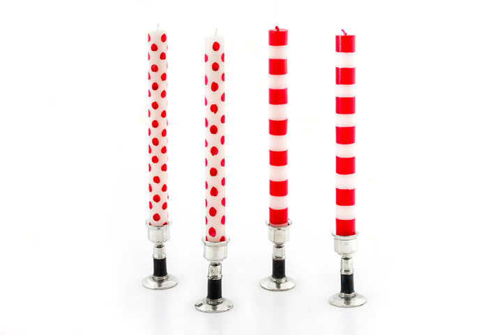 A collection of pewter candle holders with a hand painted black band, holding Red dot & stripe  candle tapers.