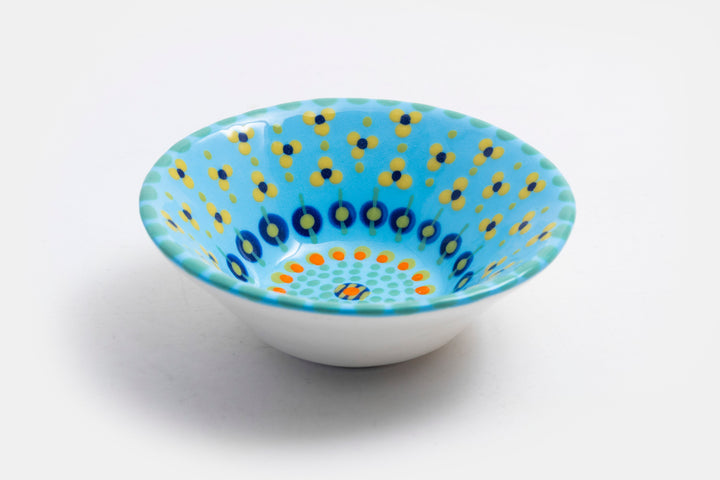 'Nut' size ceramic bowl with Baby blue base color. Dots & Stripes and flowers painted on top in orange, jasper green, turquoise blue & yellow.