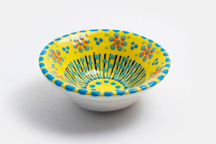 'Nut' size ceramic bowl with yellow  base color. Dots & Stripes and flowers painted on top in orange, jasper green, turquoise blue & indigo.
