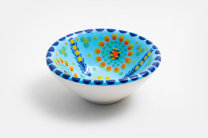 Tiny ceramic bowl, baby blue  in background with mixed patterns of dots & stripes in different sizes and colors. Microwave & Dishwasher safe.