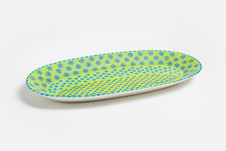Serving platter with lime green base color, painted with dots, stripes and flowers in indigo, orange, yellow, and baby blue.  Microwave and dishwasher safe.