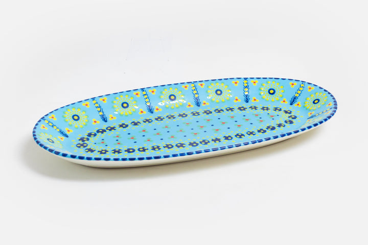 Serving platter with baby blue base color, painted with dots, stripes and flowers in indigo, orange, yellow, lime green and touches of red.  Microwave and dishwasher safe.