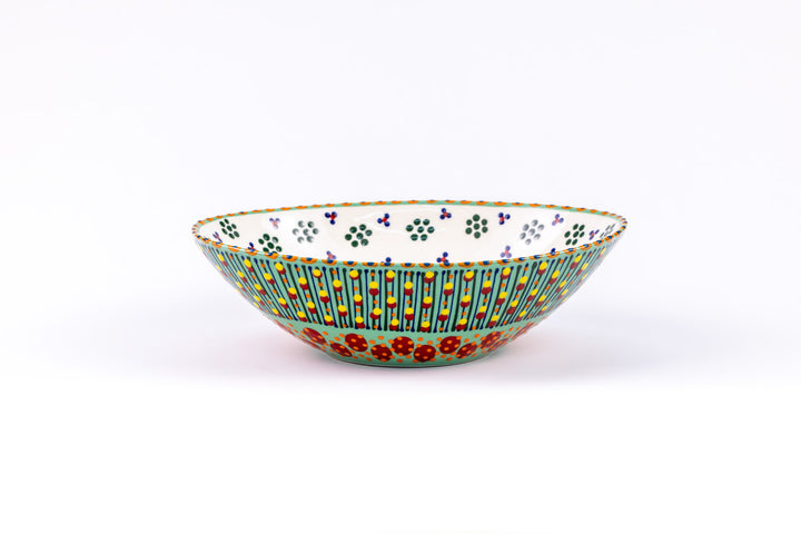 Oval ceramic serving bowl with jasper green base color. Red, orange, yellow & blue dots & stripes on top.  Inside is white with green 'dot' flowers.  Lovely!