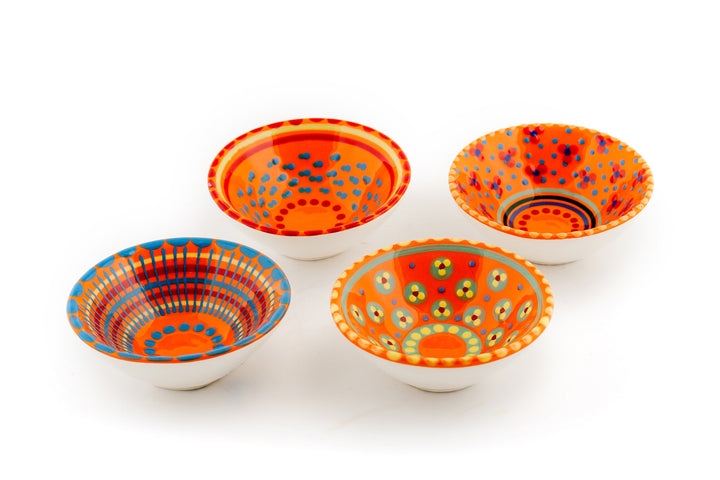 Tiny ceramic bowl, orange background with mixed patterns of dots & stripes in different sizes and colors.