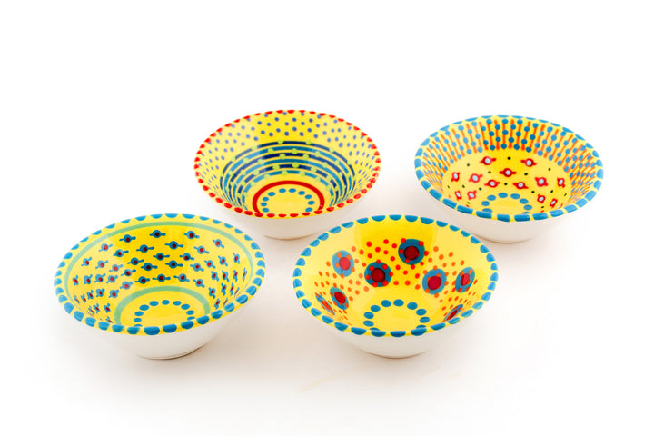 Tiny ceramic bowl, yellow in background with mixed patterns of dots & stripes in different sizes and colors.