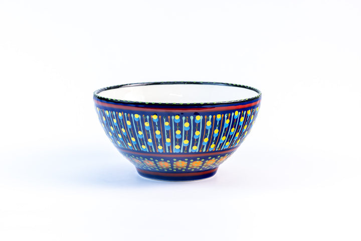 Ceramic serving bowl with base color of Indigo Blue.  Dots & Stripes painted on top in fun colors of yellow, turquoise, orange & red.  White inside the bowl.