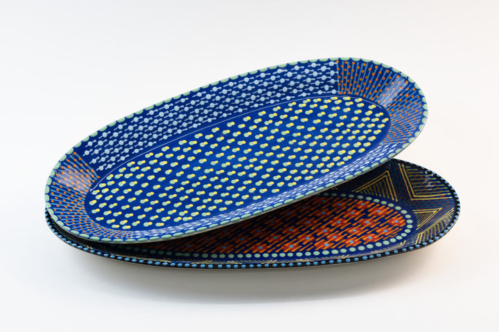 Two ceramic serving platters with Indigo Blue base color. Dots & Stripes painted on top in red, yellow, Jasper Green, and orange. Such an eye-catcher!