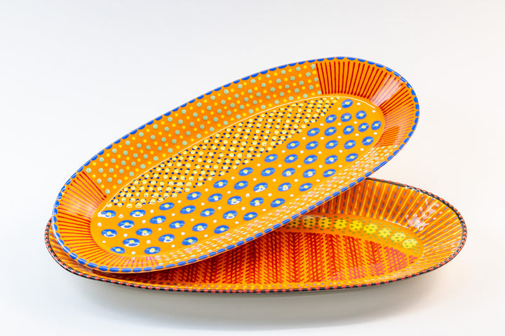 Two ceramic serving platters with Orange base color. Dots & Stripes painted on top in red, yellow, Jasper Green, and blue. Such a pop of color for your dining table!