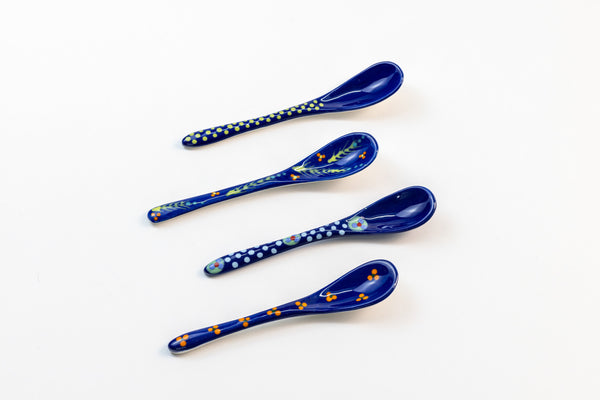 Small ceramic spoons with base color of Indigo Blue.  Tiny dots & flowers painted on top in yellow, green, light blue, and red. Very sweet!