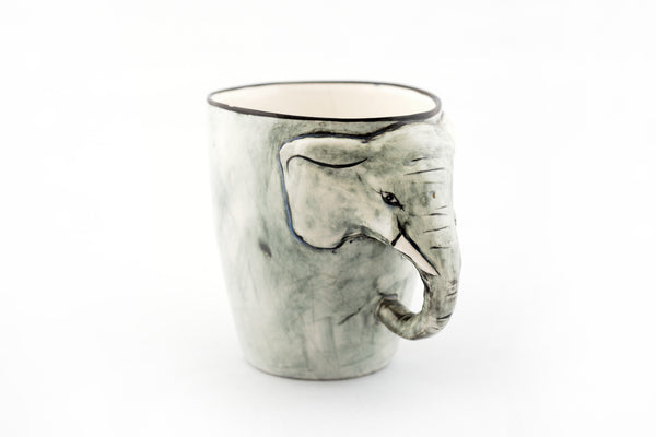 Ceramic mug painted in grey with an elephant head on the side and his truck is the handle!  Whimsy and fun!  