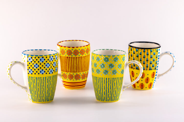 4 Very colorful coffee mugs with yellow base color.  Topped with dots & stripes in turquoise, orange, green, light & indigo blue.  Very fun!