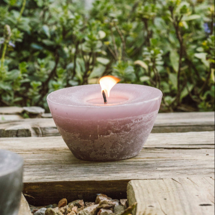 Dusty pink outdoor bowl candle burning in the garden