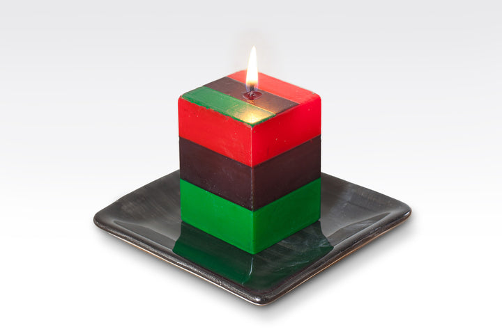 2" x 2" x 3" hand poured and hand painted candle cube. Striped in South African colors of red, green, and black. Created with Kwanzaa in mind! Fair Trade.