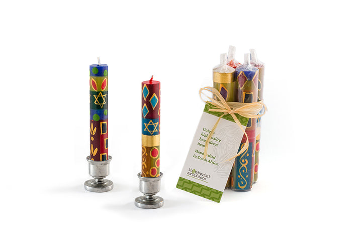 4" Shabbat tapers with Judaica design. Colorful dark blue, red, green, with touches of gold. Small Star of David hand painted on candles. Shipped in a pack of 4 with story card.