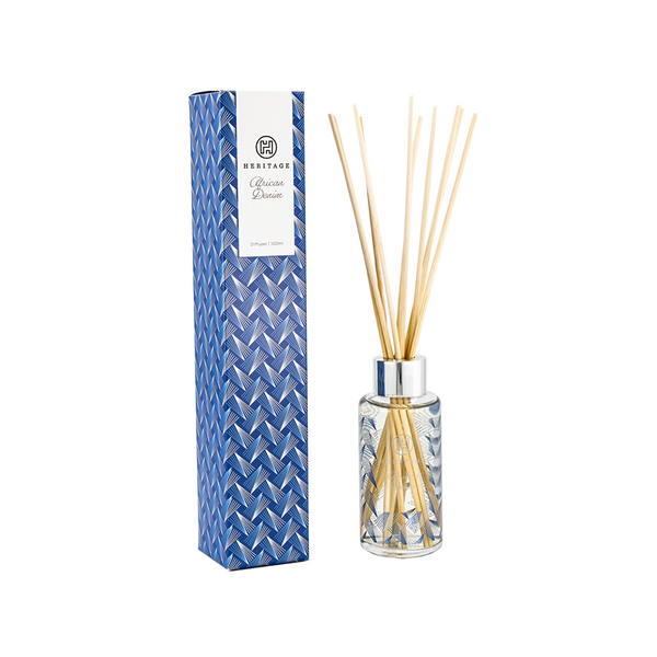 African Heritage 100ml room diffuser next to blue denim print gift box.  The diffuser glass also has the blue denim print and long blond wood sticks.  VERY attractive!  Hand made in South Africa, fairly traded.