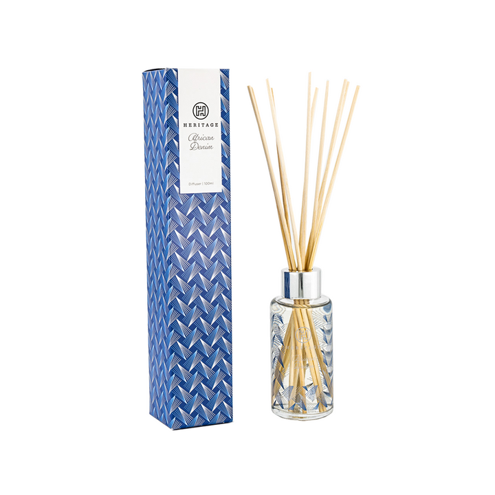 African Heritage 100ml room diffuser next to blue denim print gift box.  The diffuser glass also has the blue denim print and long blond wood sticks.  VERY attractive!  Hand made in South Africa, fairly traded.
