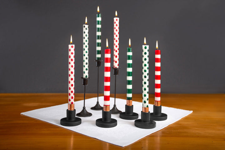 Collection of Red dots & stripes on white and Green dots & stripes on white taper candles in black taper holders.  Simple elegance. Fair Trade. Hand crafted.
