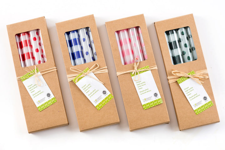 All four dots & stripe taper candle gift boxes.  Red dots & stripes, Blue dots & stripes, pink dots & stripes, and green dots & stripes. Each kraft gift box is tied with a story card.