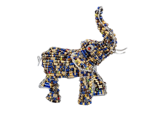 Beaded elephant figurine made of recycled silver wire and a mix of opaque and transparent beads. Hues of yellow, gold, blue, olive green, and dark browns make up the colorful beads that are strung around the wire structure, with pops of red. Wire swirled eyes with red beads. Trunk Up for good luck! Fair Trade Decor. Fair Trade Gifts. Handmade Gifts. Handmade Decor. Handbeaded.