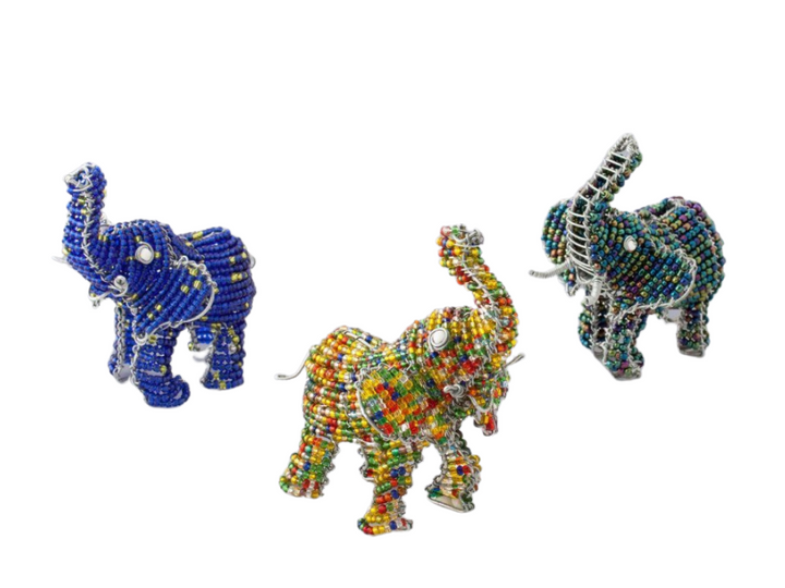 Group of three African Elephants handmade from recycled materials and beads. The trunk is up for Good Luck! From left to right, blue beads with some yellow beads sprinkled in, middle is a colorful elephant with beads of red, orange, yellow, green, and blue, far right is an elephant with metallic style beads of teal, purple, olive green.