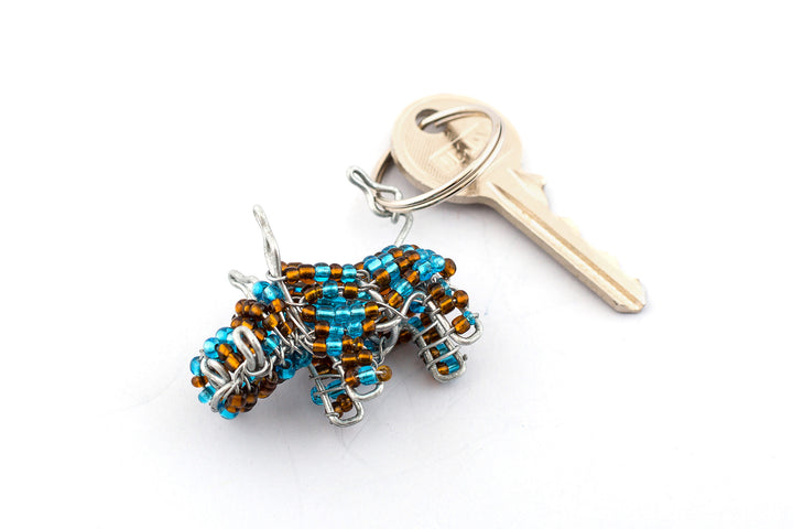 Beaded warthog key chain. Handmade in turquoise & brown beads. Looks mean and very cute at the same time! Fair Trade products.