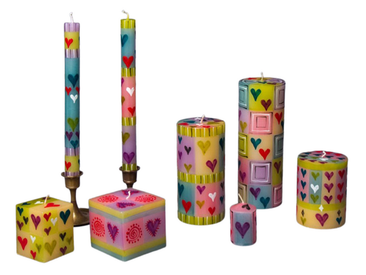 Pastel Hearts hand made and hand painted candle collection.  Light blue, yellow , pink, badkgrounds with hearts painted in purple, red, pink, and white.  Very fun and happy!  Fair Trade home decor. 